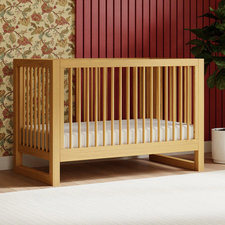 Namesake's Nantucket 3-in-1 Convertible Crib next to plant in -- Color_Honey