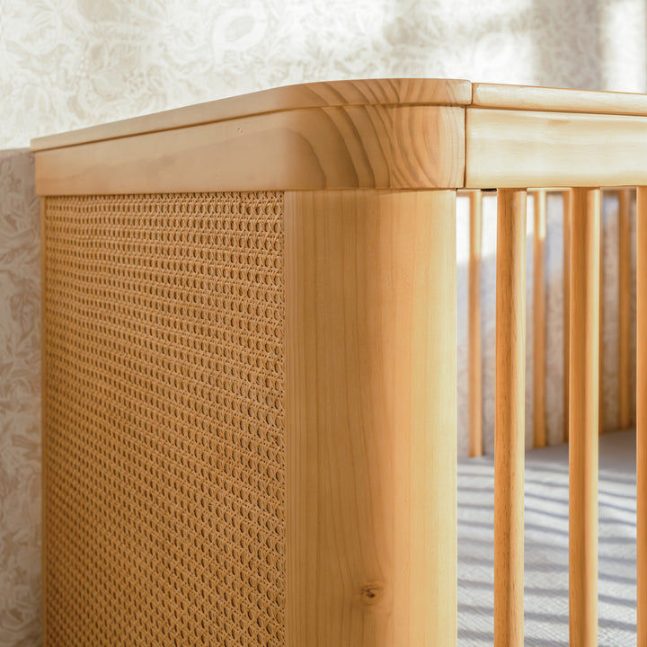 Closeup of The Namesake Marin 3-in-1 Convertible Crib rail in -- Color_Honey/Honey Cane