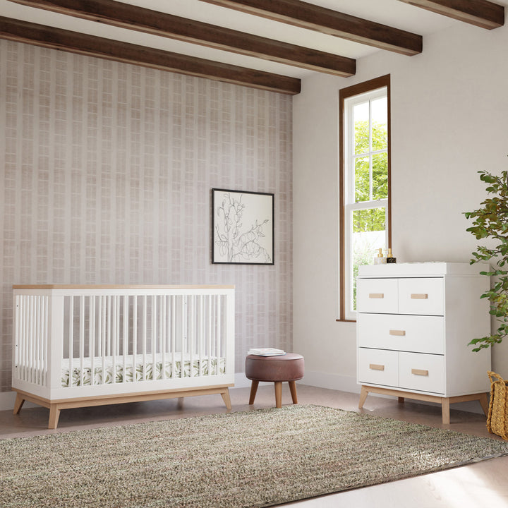 Babyletto's Scoot 3-in-1 Convertible Crib + Toddler Rail next to a dresser and stool  in -- Color_Washed Natural/White