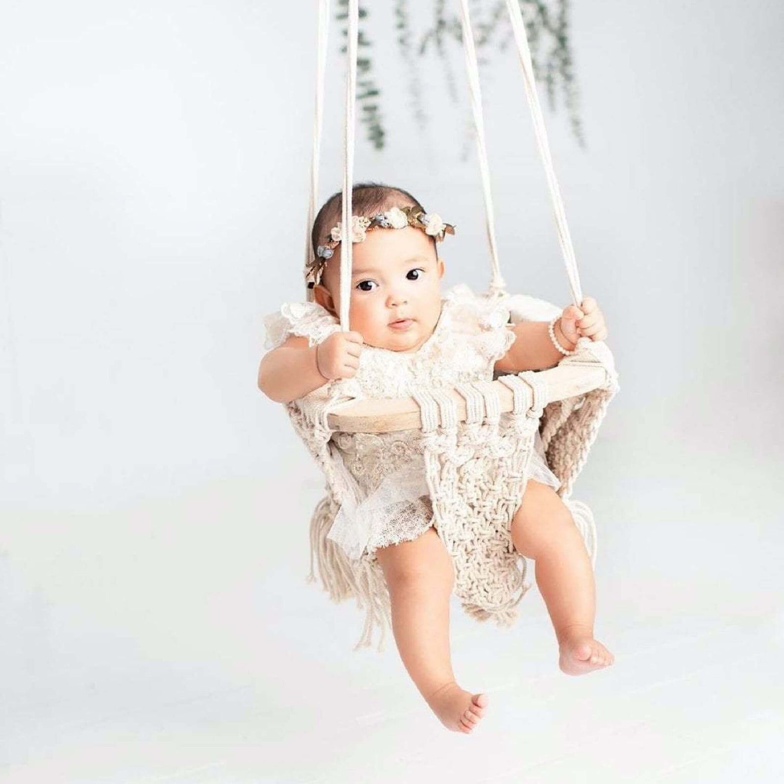 baby wearing flower crown swinging in finn+emma macrame swing