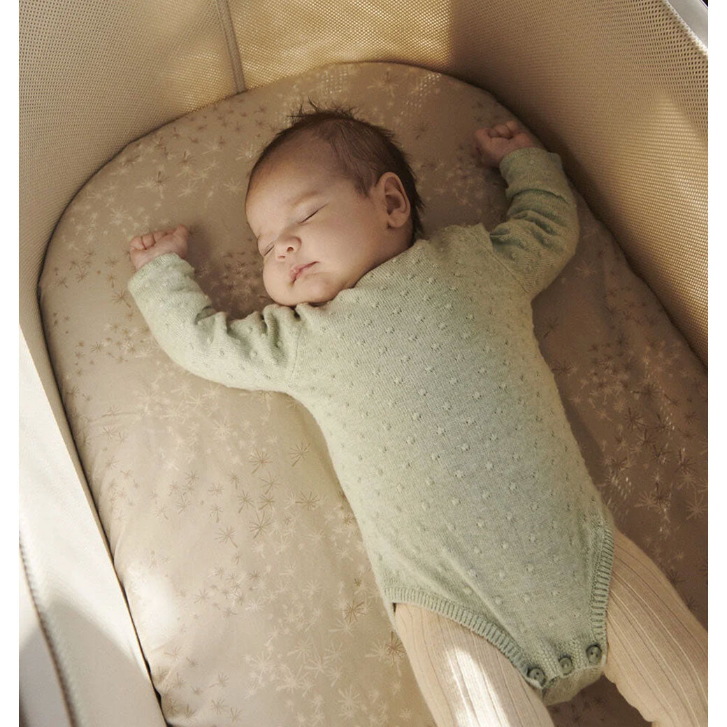 Baby sleeping in the Stokke Snoozi Bassinet in -- Color_Sandy Beige