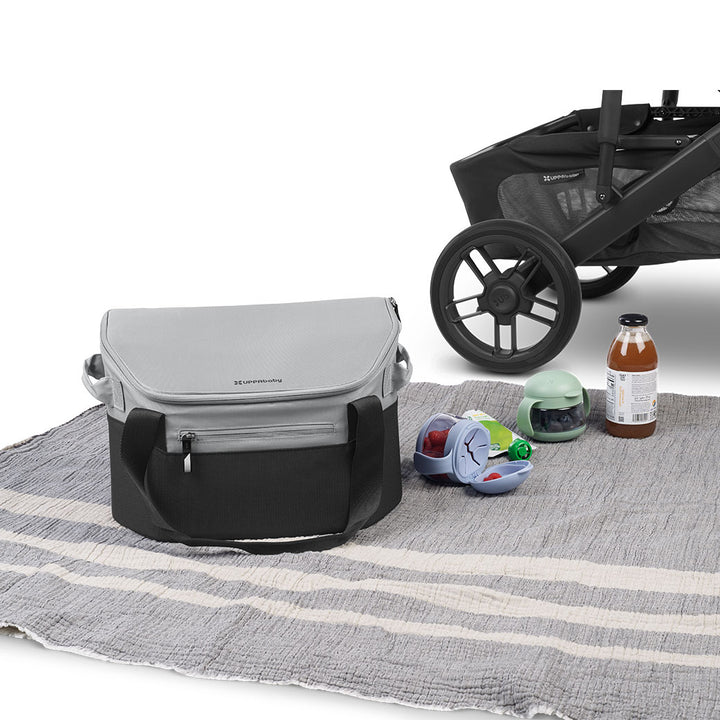 UPPAbaby Bevvy Stroller Basket Cooleran a picnic blanket next to a stroller, food, and beverages 