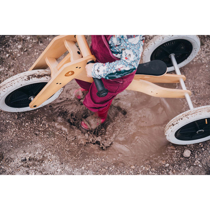 Toddler riding the OB-135 3-in-1 Bike on muddy road