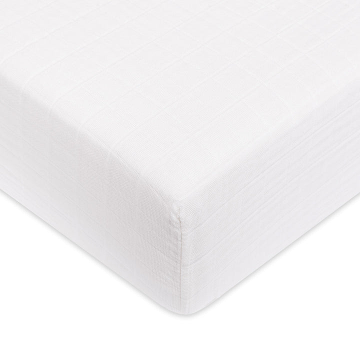 A closeup of the Babyletto's Crib Sheet in GOTS Certified Organic Muslin Cotton corner in -- Color_White