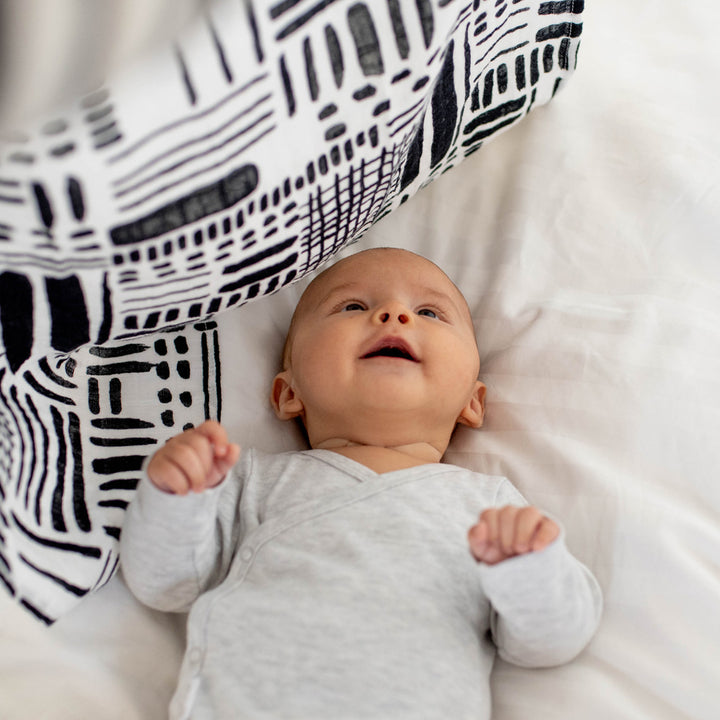 Baby looking up at the The Etta Loves Sensory Muslin in -- Color_Drawing