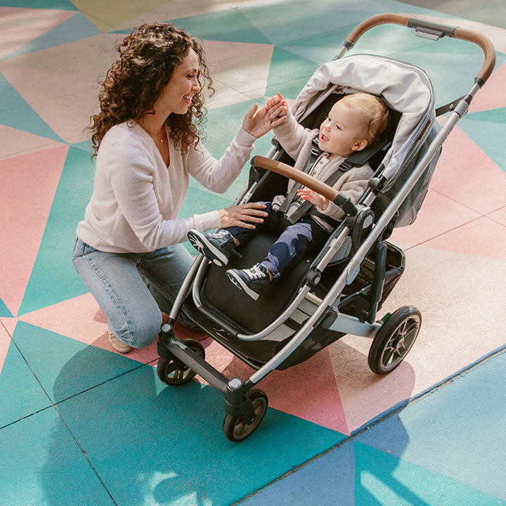 Mom with baby in the UPPAbaby Cruz V2 Stroller in -- Color_Gregory