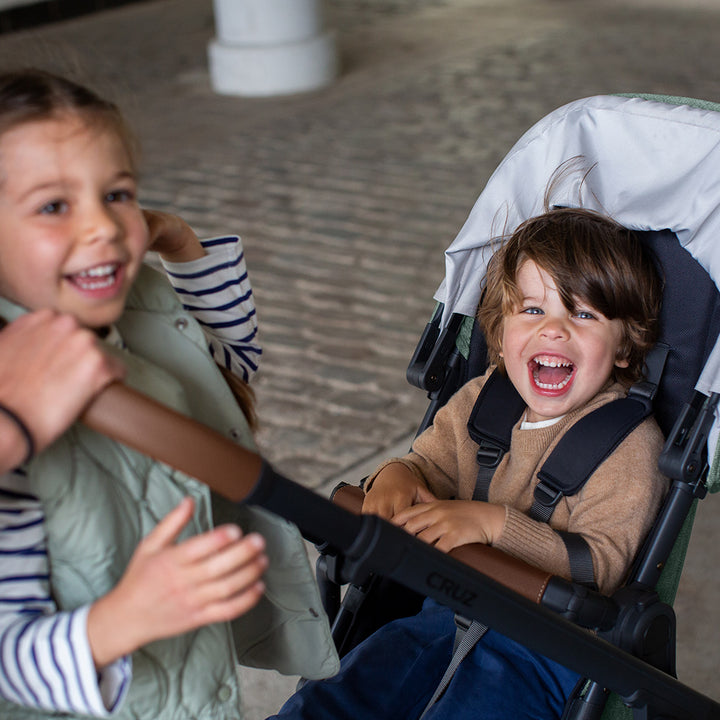 A toddler sitting in the UPPAbaby CRUZ V2 Stroller in -- Color_Gwen