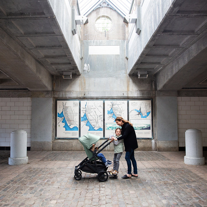 A mom smiling and looking at her toddler in the UPPAbaby Cruz V2 Stroller in -- Color_Gwen