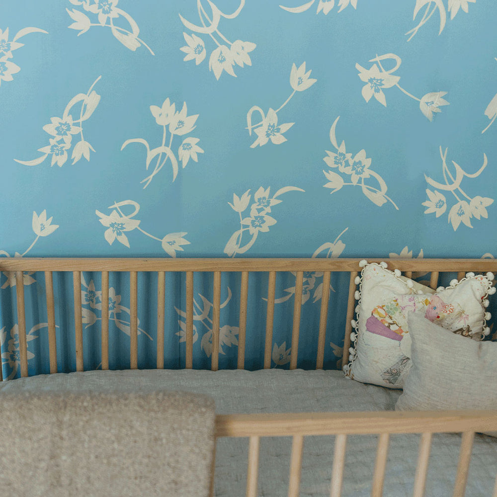 A baby crib next to the Anewall After The Rain Floral Mural