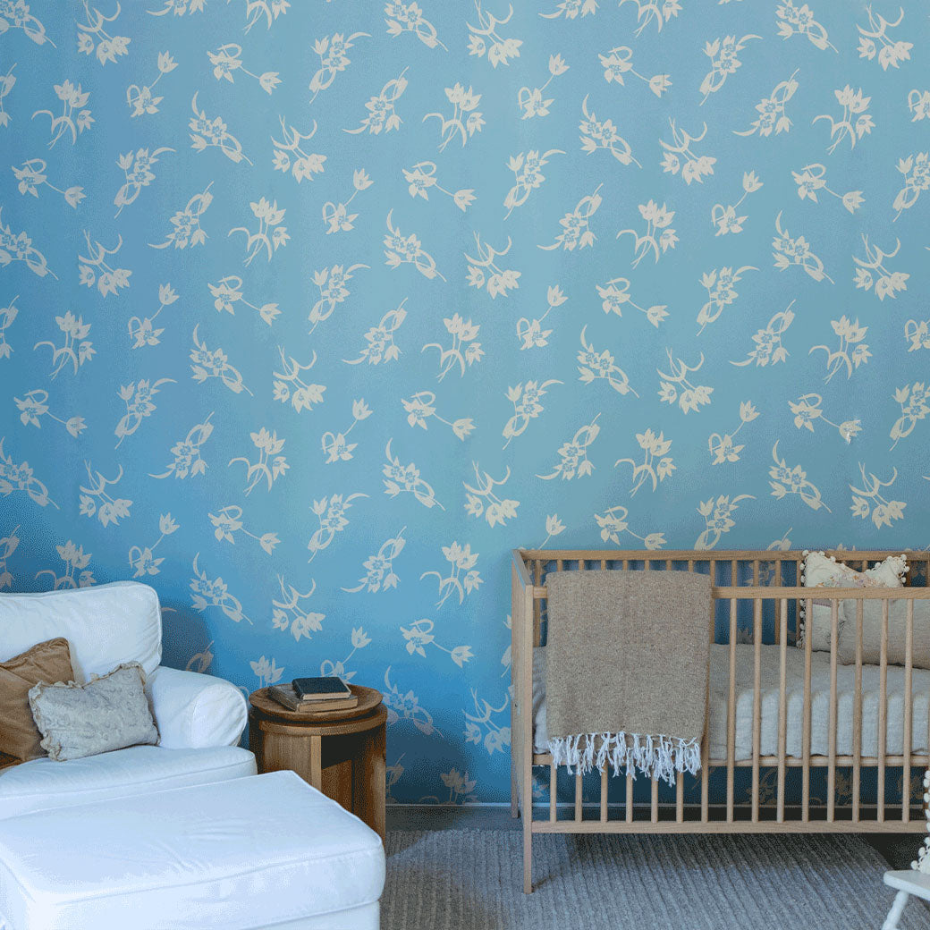 A crib and chair next to a wall furnished with Anewall After The Rain Floral Mural