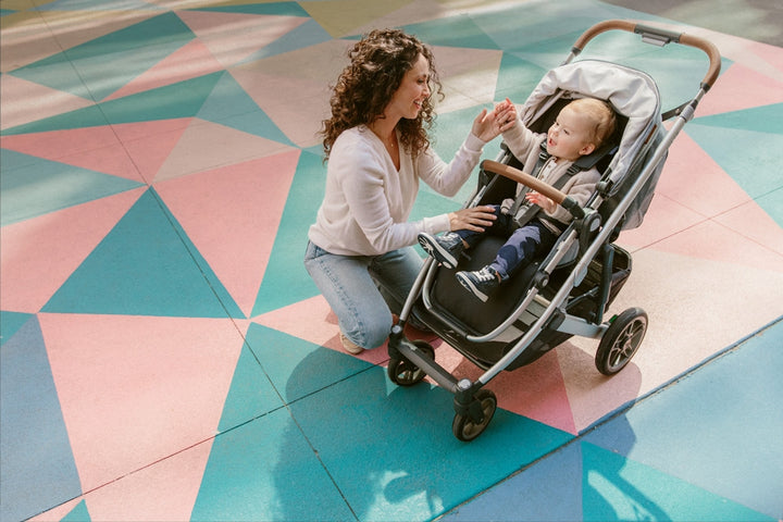 Mom playing with a baby in the UPPAbaby CRUZ V2 Stroller in -- Color_Gregory