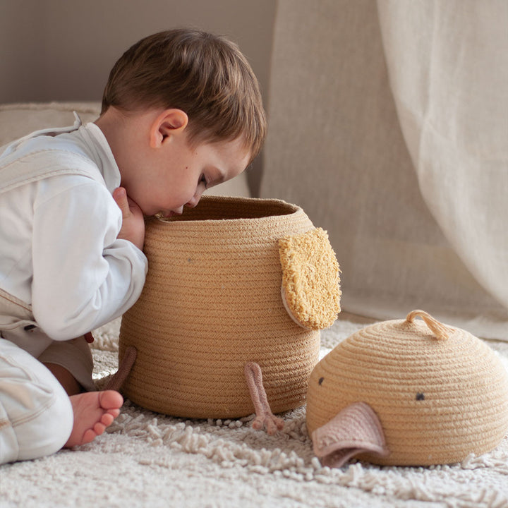 Side view of a child looking inside of the Lorena Canals Charlie the Chicken Basket 