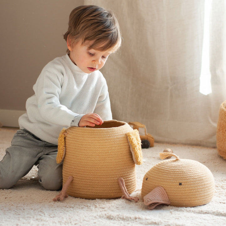 A child looking inside of the Lorena Canals Charlie the Chicken Basket 