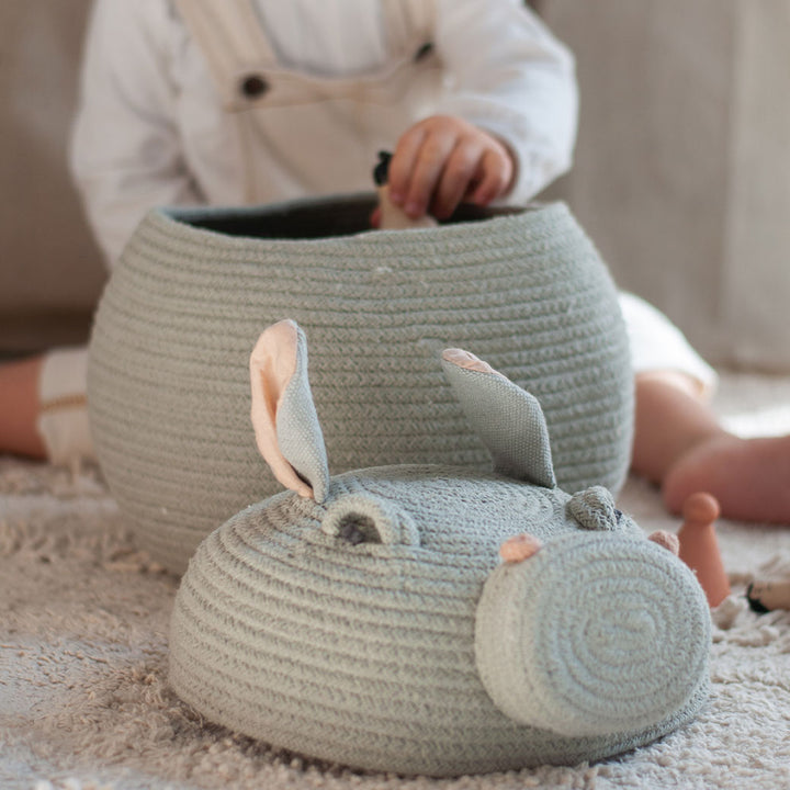 A child putting an item in the Lorena Canals Henry the Hippo Basket