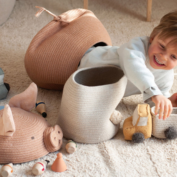 A child playing with toys and the Lorena Canals Peggy the Pig Basket