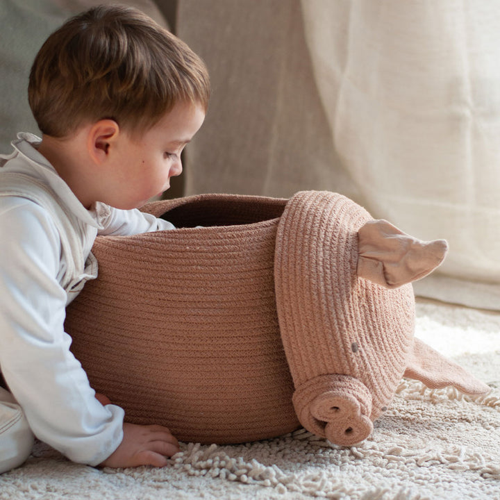 A child looking inside the Lorena Canals Peggy the Pig Basket