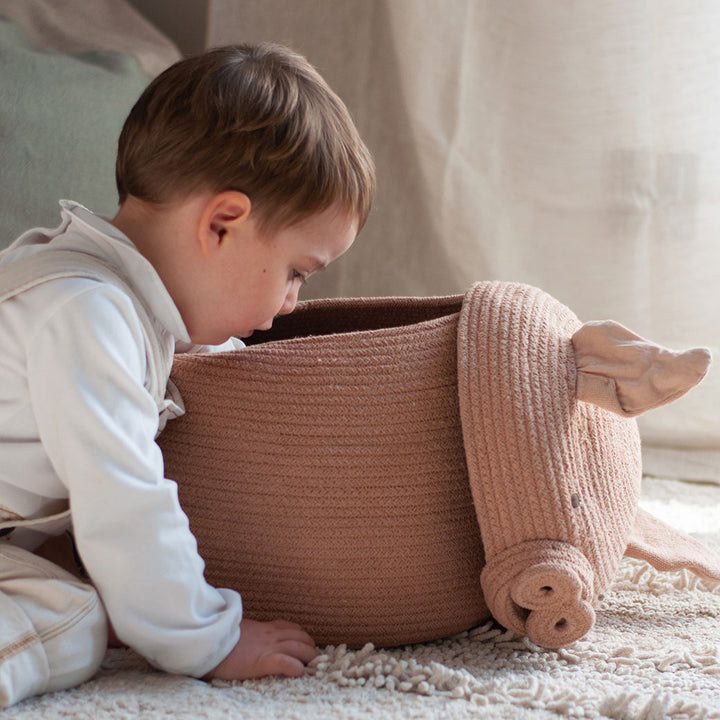 A baby looking inside the Lorena Canals Peggy the Pig Basket