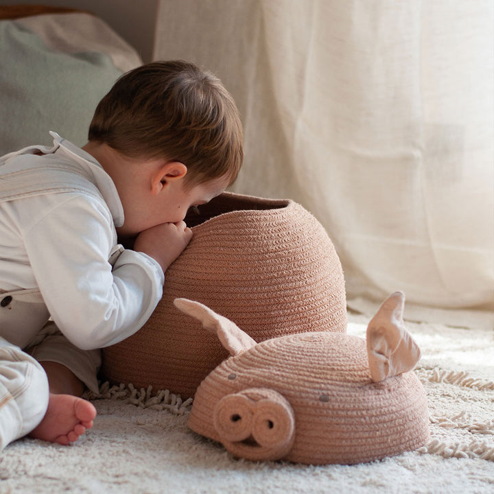 A child playing and looking inside the Lorena Canals Peggy the Pig Basket