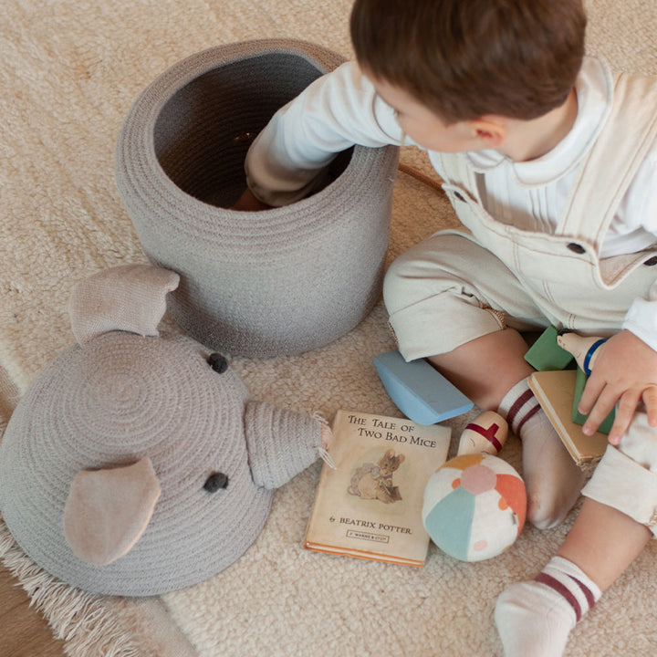 A child reaching inside the Lorena Canals Renata the Rat Basket