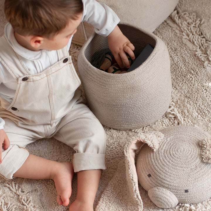 A child reaching inside of the Lorena Canals Rita the Rabbit Basket