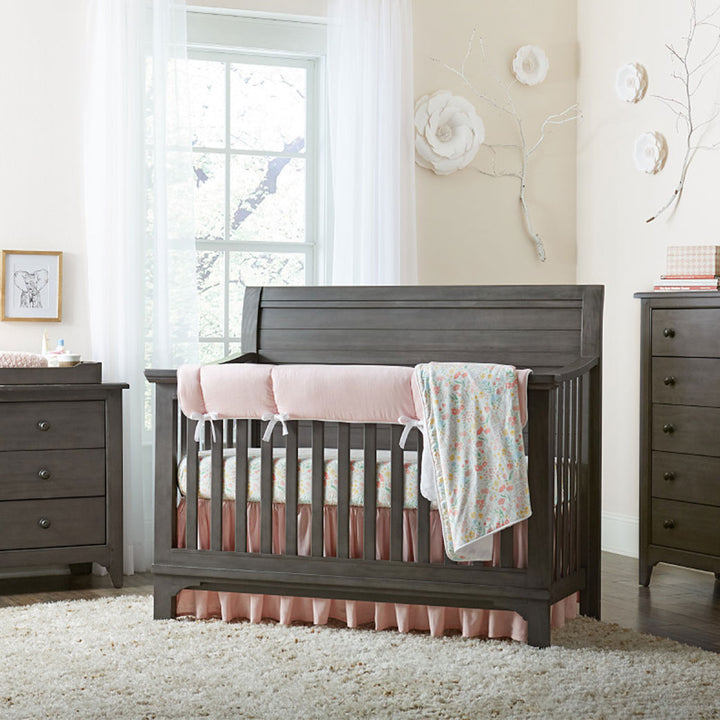 Westwood Design Taylor Convertible Crib next to drawer dresser, with blanket over the rail  in -- Color_Dusk