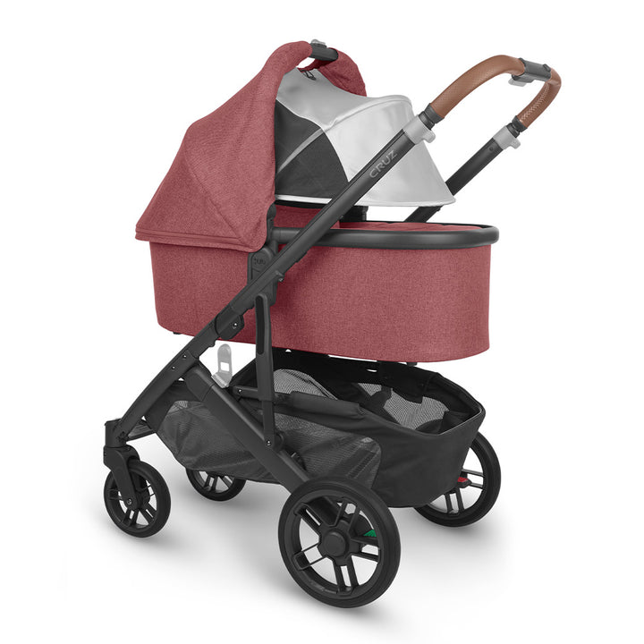 Angled view of reversed bassinet with sunshade down on UPPAbaby Cruz V2 Stroller in -- Color_Lucy